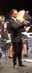 The dark curly-haired man with the big legs